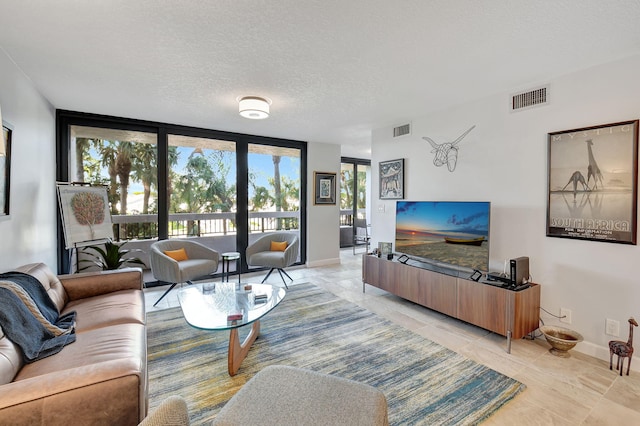 tiled living room featuring a textured ceiling