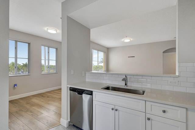 kitchen featuring dishwasher, sink, white cabinetry, and backsplash