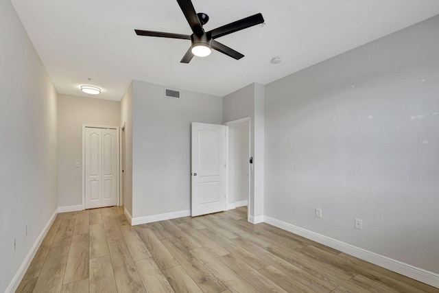 unfurnished bedroom with a closet, light hardwood / wood-style flooring, and ceiling fan