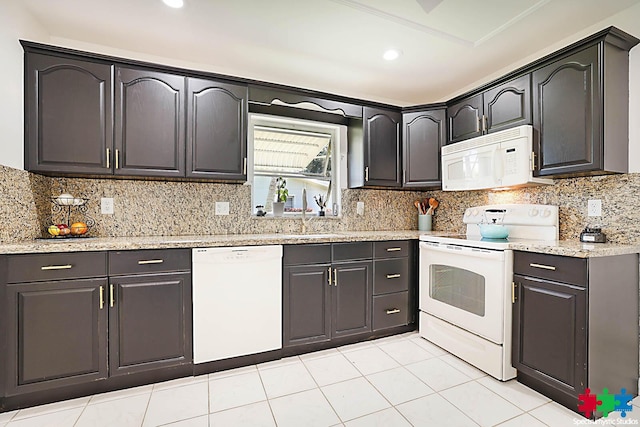 kitchen with decorative backsplash, light stone countertops, white appliances, sink, and light tile patterned flooring