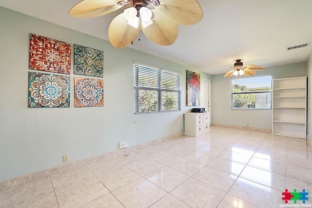 unfurnished room with ceiling fan and light tile patterned flooring