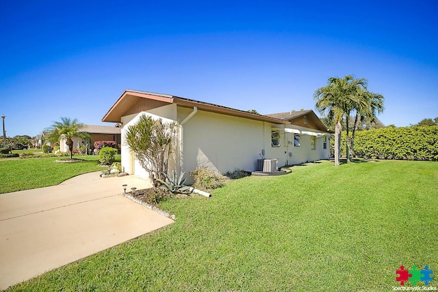 view of side of home featuring a lawn and central AC unit