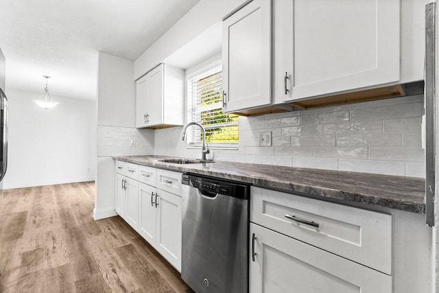 kitchen with white cabinets, sink, dark stone countertops, dishwasher, and hardwood / wood-style floors