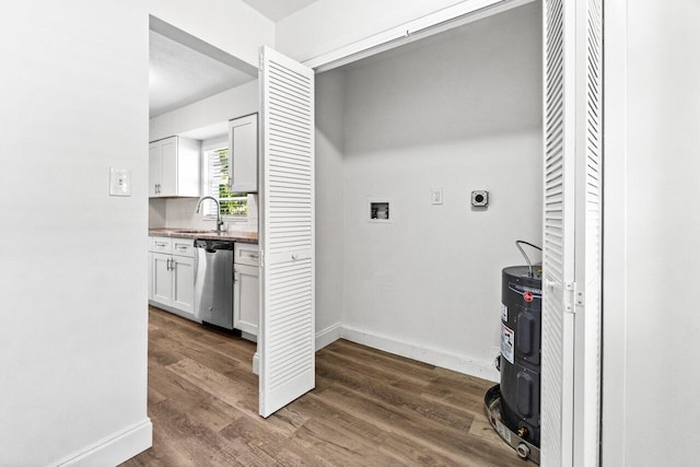 interior space with electric dryer hookup, dark hardwood / wood-style flooring, hookup for a washing machine, and sink