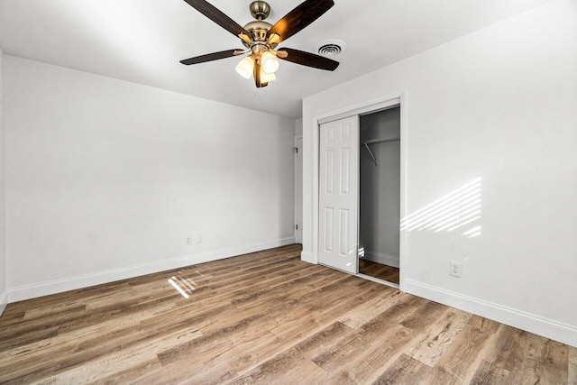 unfurnished bedroom featuring hardwood / wood-style flooring, ceiling fan, and a closet