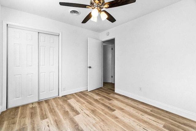 unfurnished bedroom with light wood-type flooring, a closet, and ceiling fan