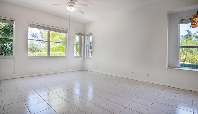 spare room with light tile patterned floors, plenty of natural light, and ceiling fan