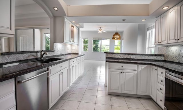 kitchen featuring white cabinetry, sink, backsplash, dark stone countertops, and appliances with stainless steel finishes