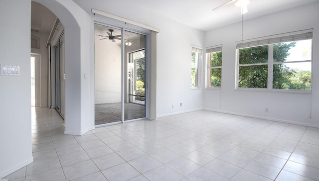 tiled spare room with ceiling fan