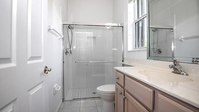 bathroom with tile patterned floors, toilet, vanity, and walk in shower