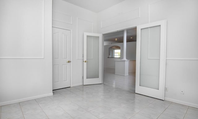 unfurnished room featuring french doors and light tile patterned flooring