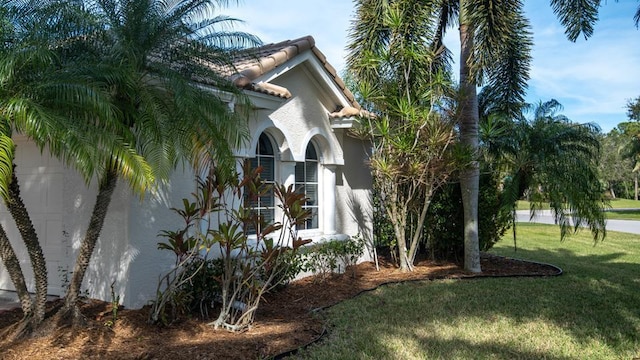 view of property exterior with a garage and a lawn