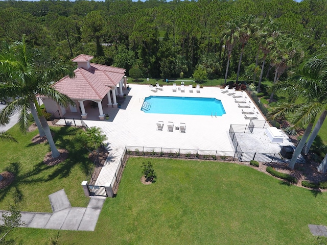 view of pool with a patio area and a yard