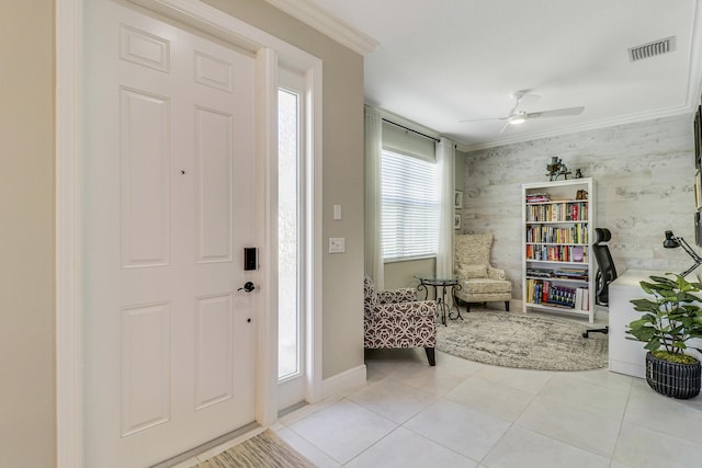 tiled foyer entrance with a wealth of natural light, crown molding, and ceiling fan