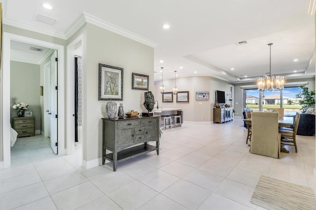 dining space with light tile patterned floors, crown molding, a tray ceiling, and an inviting chandelier