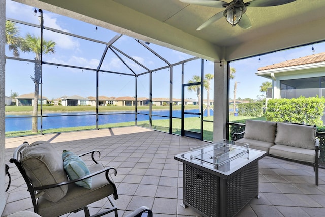 view of patio featuring an outdoor living space, ceiling fan, glass enclosure, and a water view