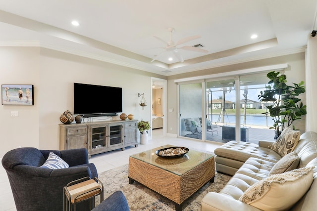 living room featuring a tray ceiling, ceiling fan, ornamental molding, and light tile patterned flooring