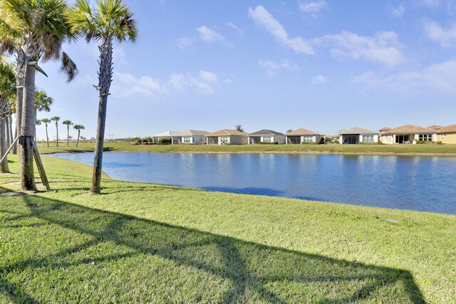 view of patio featuring glass enclosure, ceiling fan, and a water view