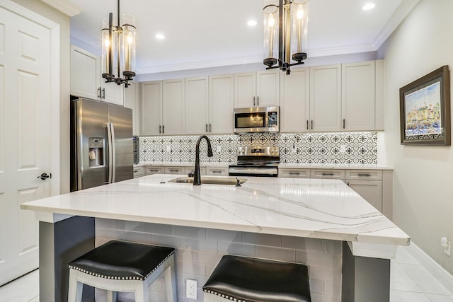 kitchen with appliances with stainless steel finishes, light stone counters, a breakfast bar, sink, and pendant lighting