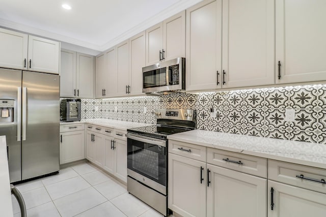 kitchen with light stone countertops, backsplash, stainless steel appliances, crown molding, and light tile patterned floors