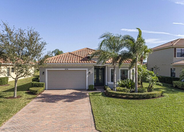 mediterranean / spanish-style house featuring a front lawn and a garage