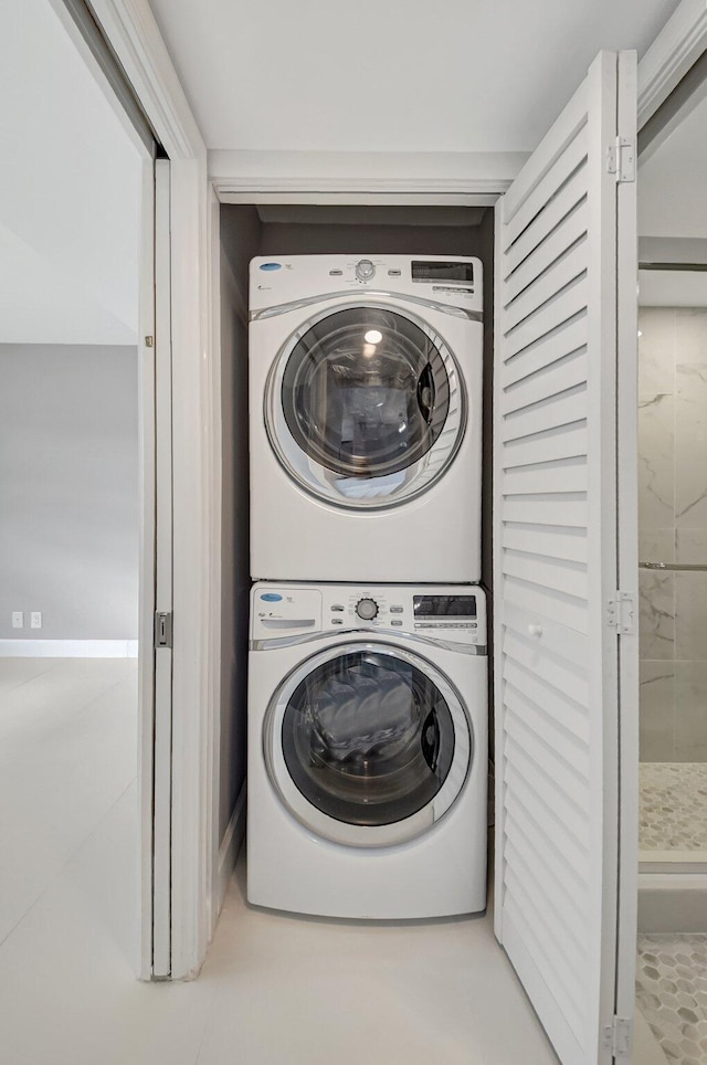 laundry area featuring tile patterned floors and stacked washer / drying machine