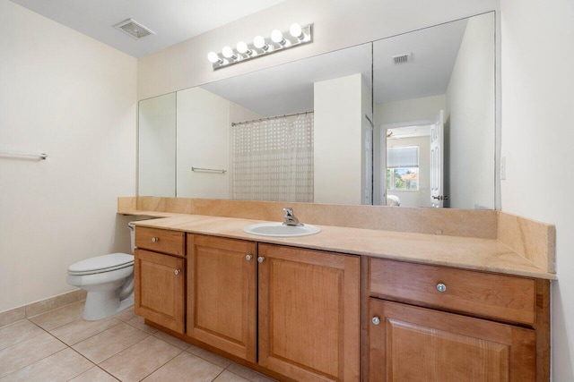 bathroom with tile patterned flooring, vanity, and toilet