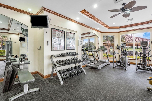 workout area with ceiling fan, a raised ceiling, and ornamental molding