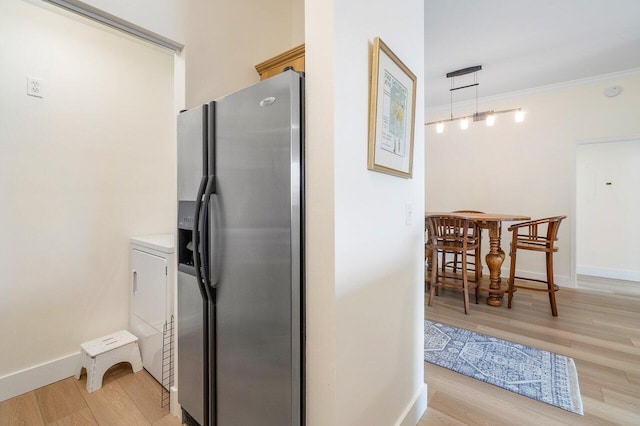 kitchen featuring light wood-type flooring, decorative light fixtures, stainless steel refrigerator with ice dispenser, and ornamental molding