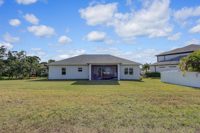 rear view of property featuring a lawn