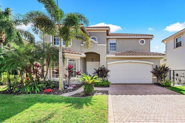 mediterranean / spanish house featuring a front lawn and a garage