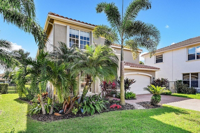 mediterranean / spanish-style house featuring a garage and a front yard