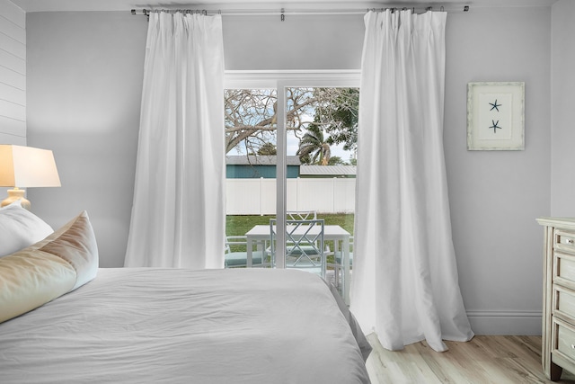 bedroom featuring light hardwood / wood-style flooring, access to outside, and multiple windows