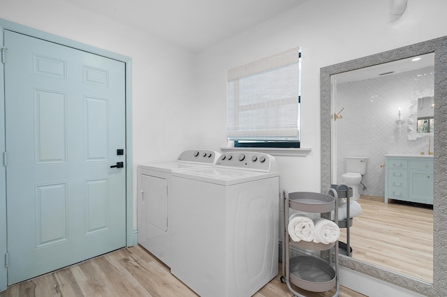 laundry room featuring light hardwood / wood-style floors and washer and dryer