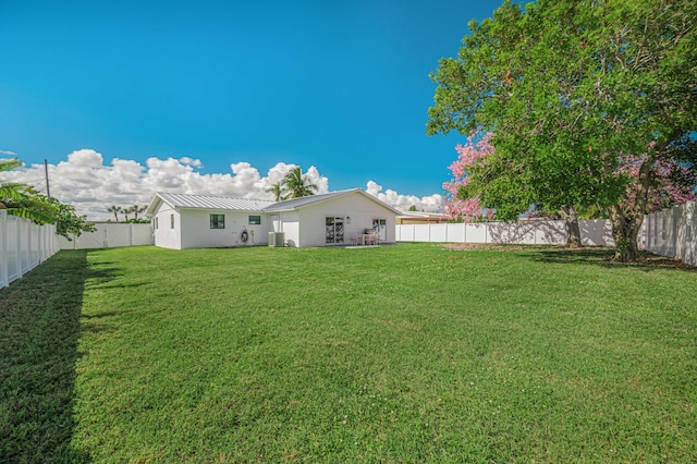 rear view of property with a lawn and cooling unit