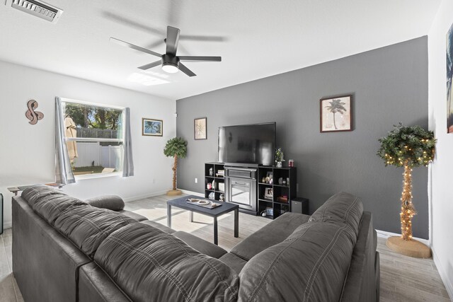 living room with ceiling fan and light hardwood / wood-style flooring