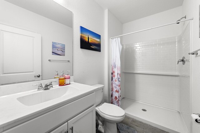 bathroom with vanity, curtained shower, and toilet