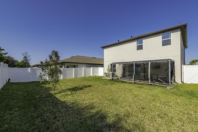 rear view of house featuring a lawn