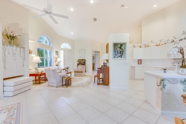 tiled living room featuring ceiling fan and high vaulted ceiling