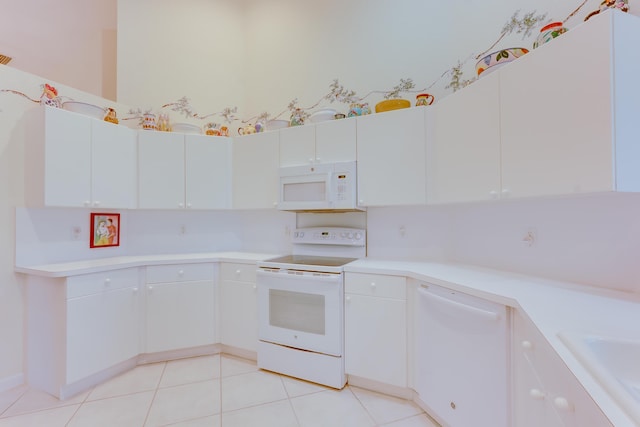 kitchen featuring light tile patterned floors, white cabinets, and white appliances