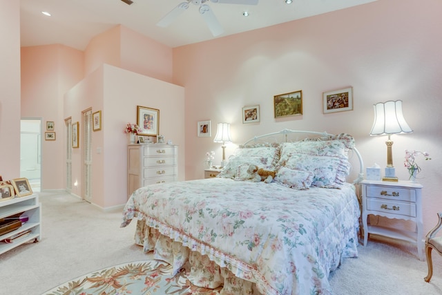 bedroom with light carpet, ceiling fan, and a high ceiling