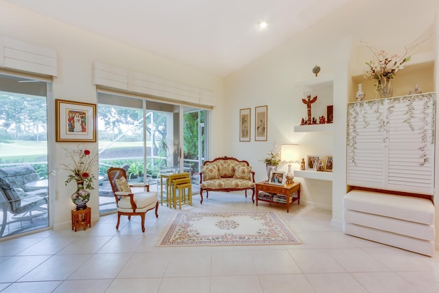 living area with high vaulted ceiling and light tile patterned floors