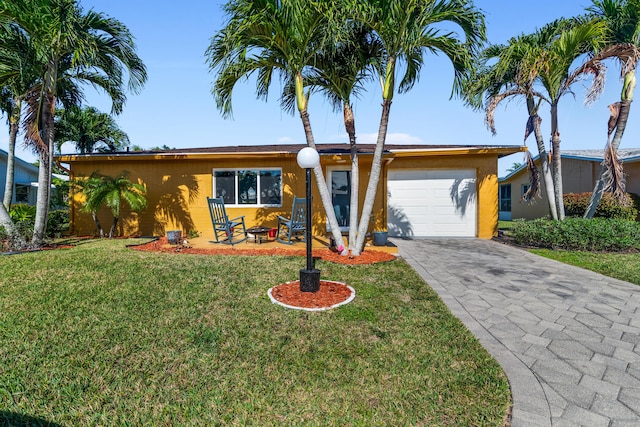 ranch-style home with a garage and a front lawn