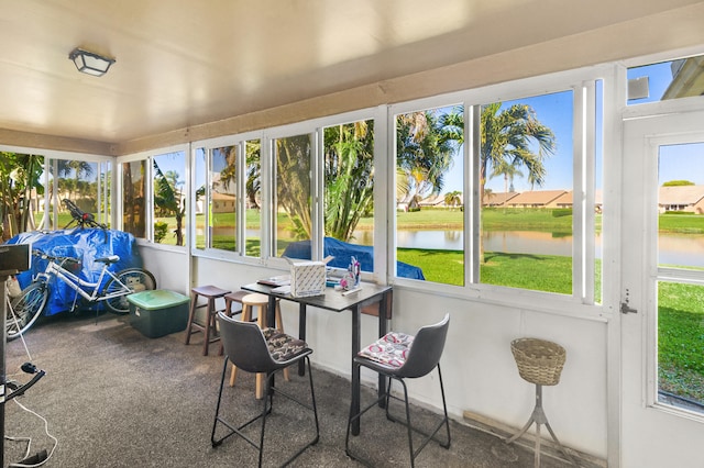 sunroom / solarium featuring a water view