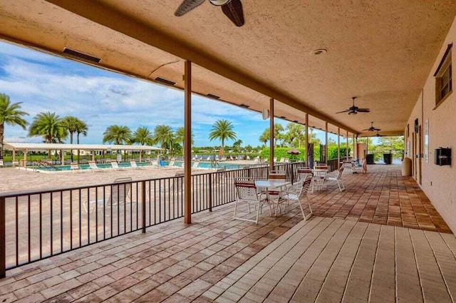 wooden terrace featuring ceiling fan and a community pool