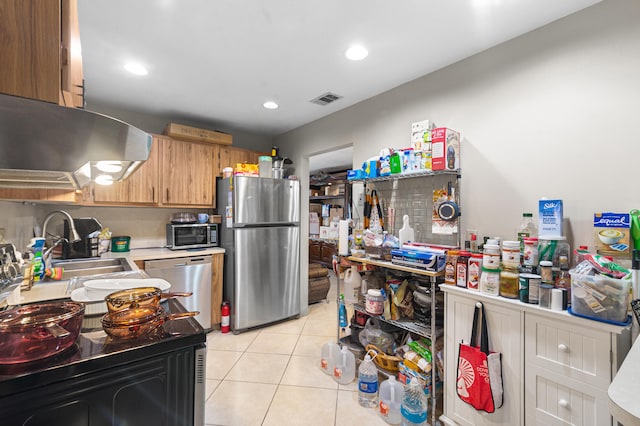 kitchen featuring appliances with stainless steel finishes, range hood, light tile patterned floors, and sink