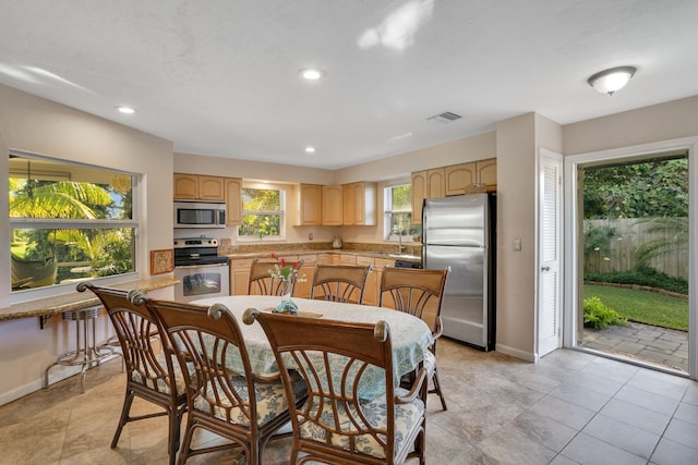 kitchen featuring light brown cabinets, light tile patterned flooring, sink, and appliances with stainless steel finishes