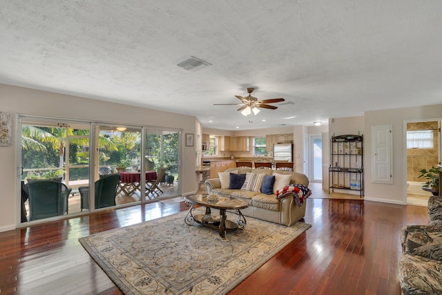 living room featuring a textured ceiling, hardwood / wood-style flooring, and ceiling fan