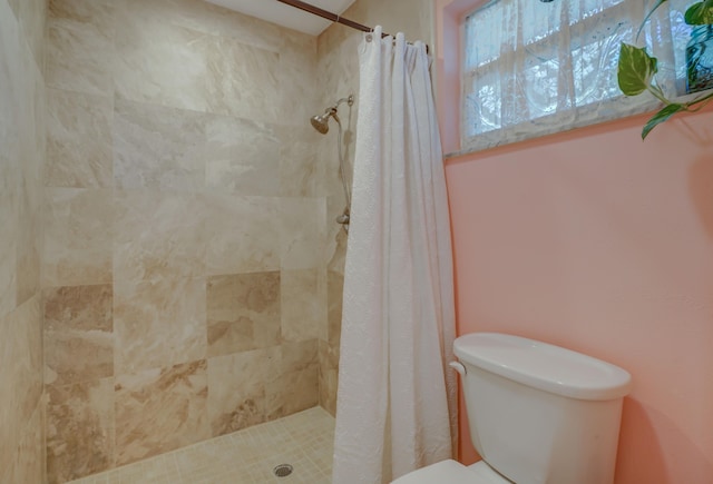 bathroom featuring curtained shower and toilet