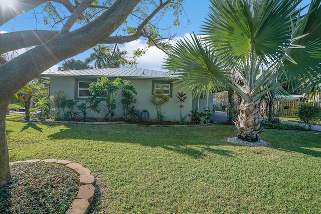 view of side of home with a yard